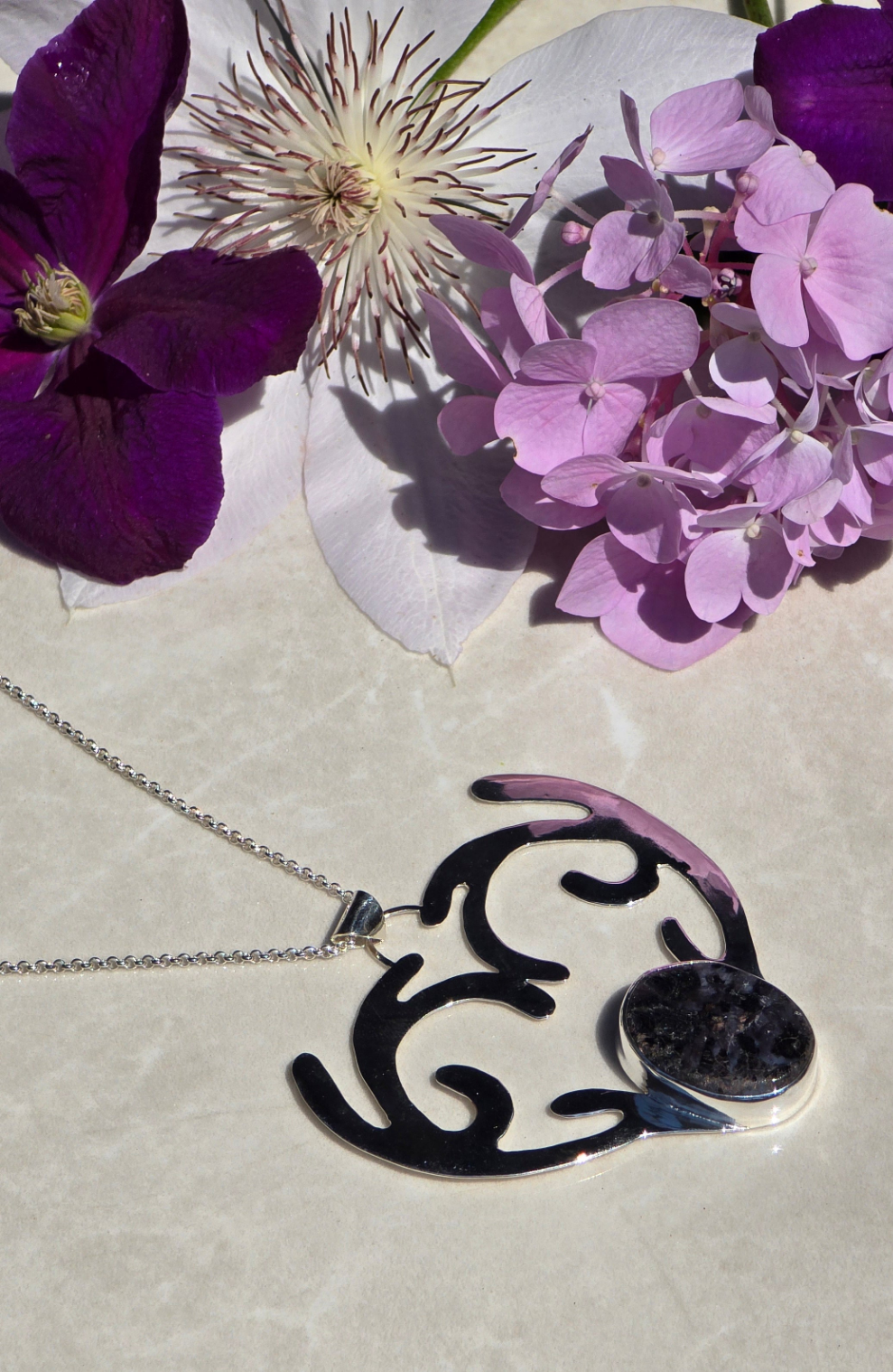 Sterling silver necklace with bezel-set oval indigo gabbro stone forming a deer's head and antlers curving into a heart on a 24-inch chain