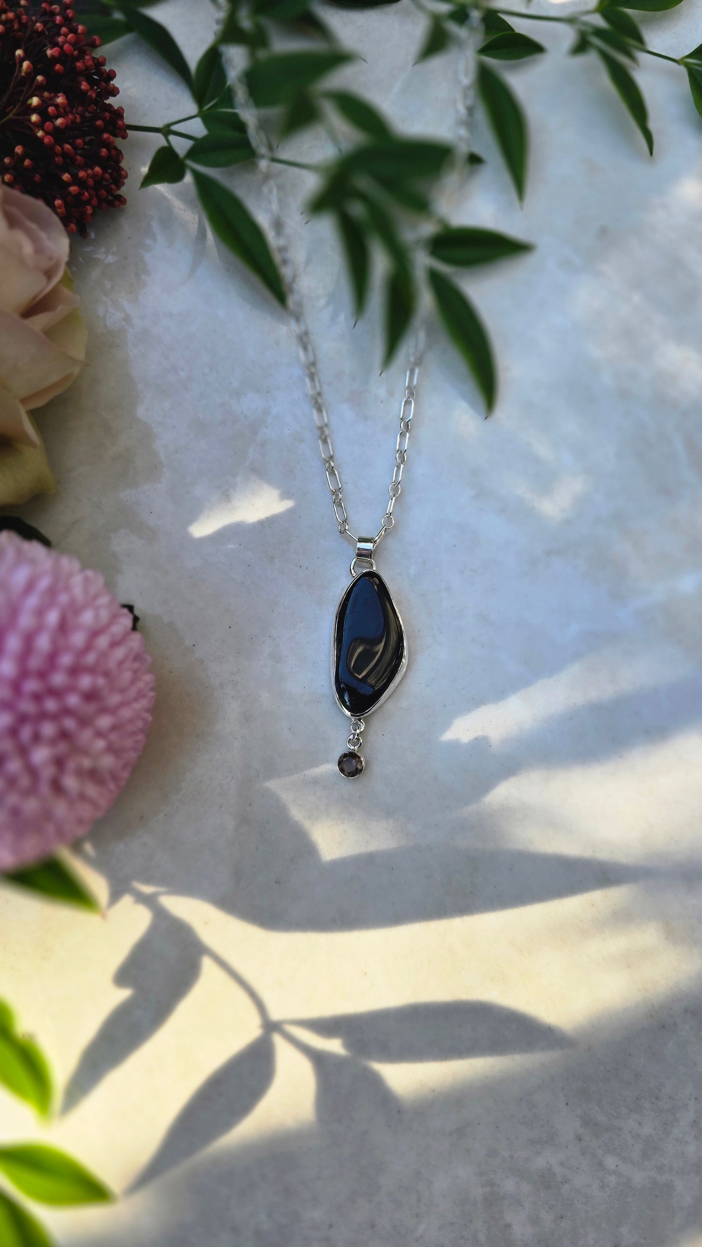 Sterling silver necklace with bezel-set black tourmaline and dangling faceted smoky quartz on 22-inch chain