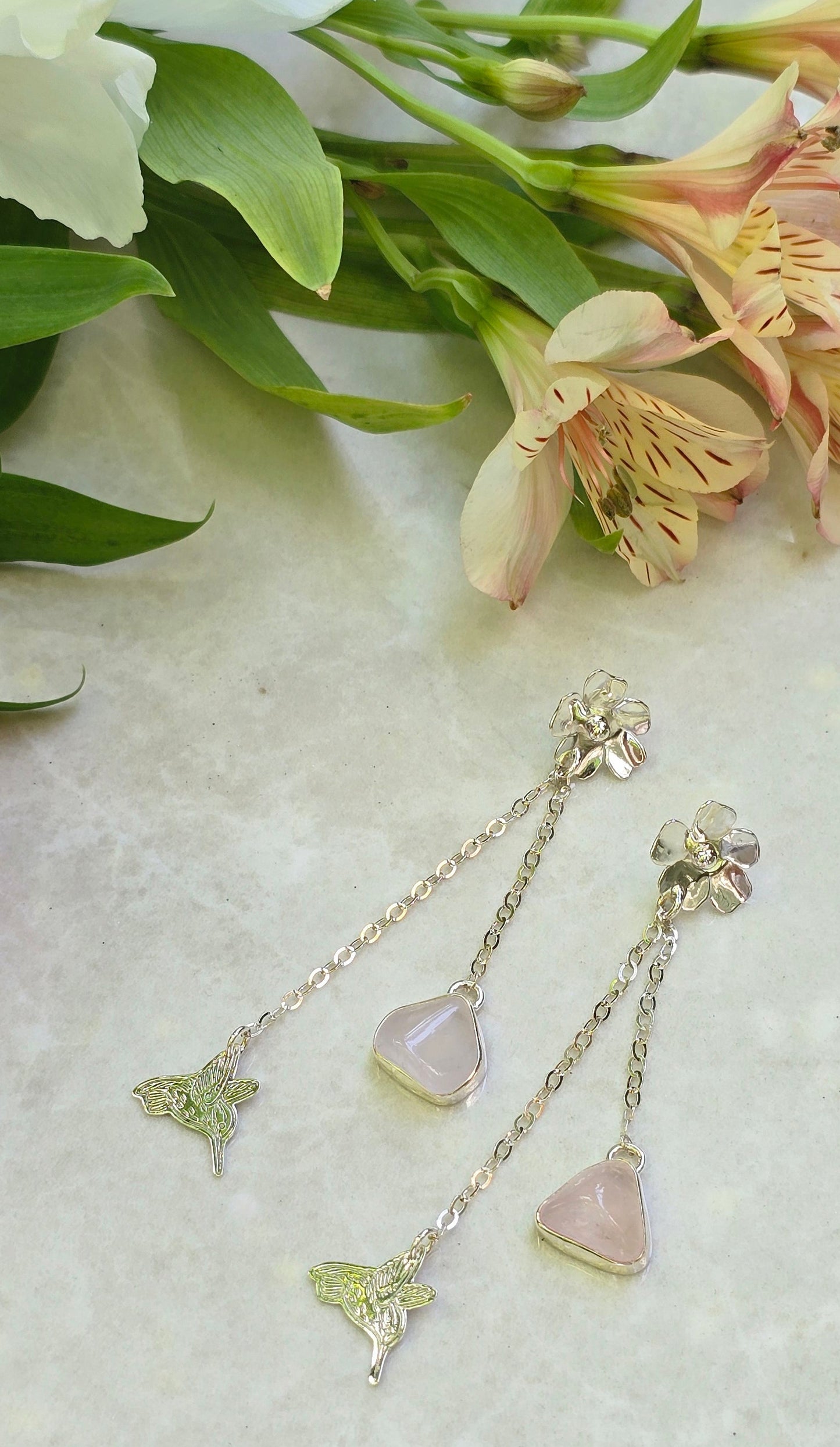 Sterling silver hummingbird dangle earrings with laser-cut hummingbird charm, rose quartz open-back bezel drop, and flower stud top with layered chains